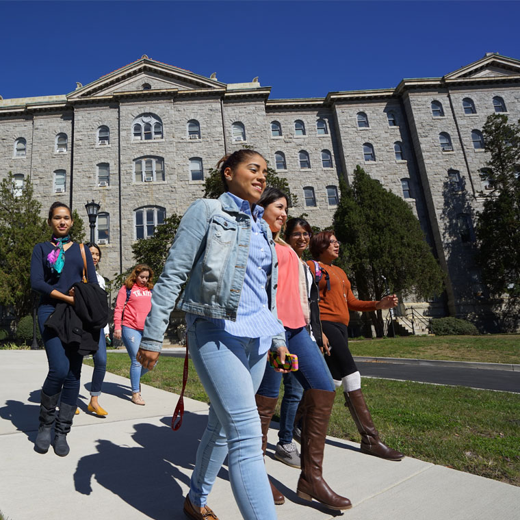 Students walking across a college campus.